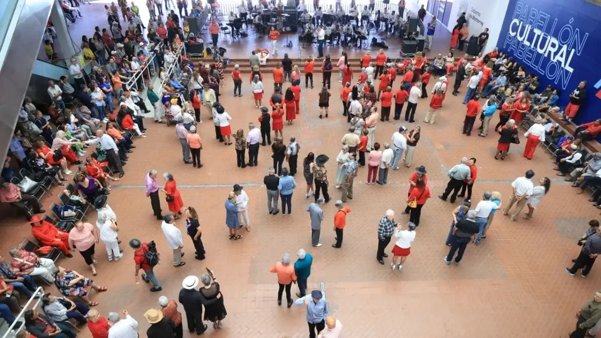 Adultos mayores disfrutan de un evento emotivo en el Palacio Municipal, fomentando la convivencia y el romance.