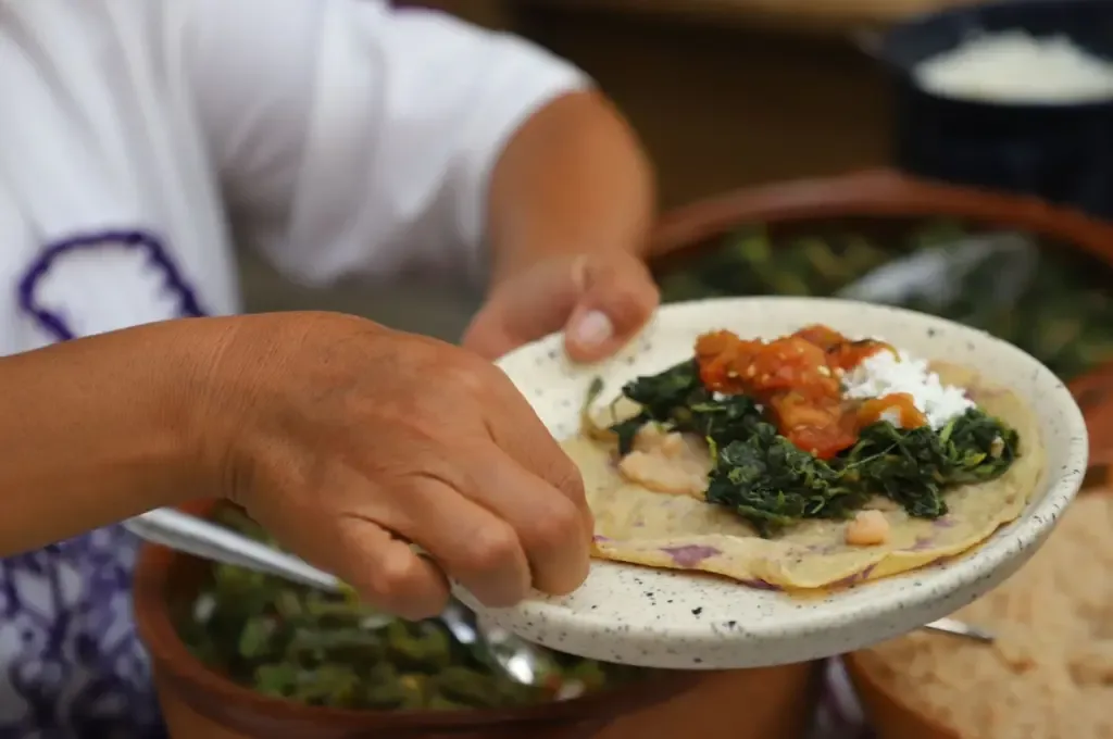 Ana María Soto Vargas mostrando sus platillos tradicionales en un evento culinario.