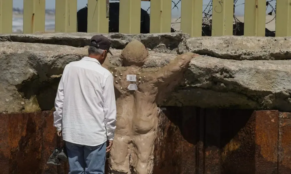 Artistas chicanos crean una obra en el muro fronterizo para honrar a los migrantes.