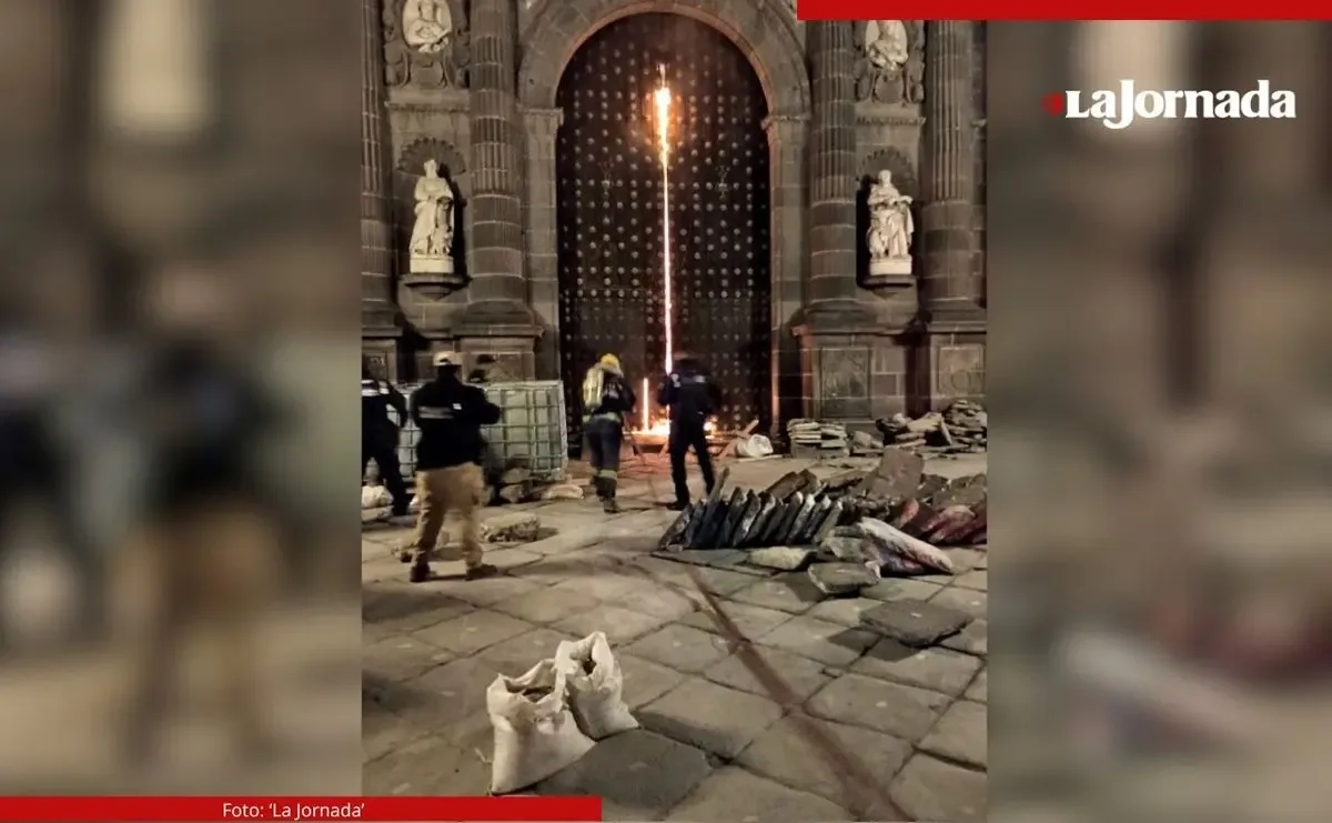 Bomberos controlan el incendio en el portón norte de la Catedral de Puebla.