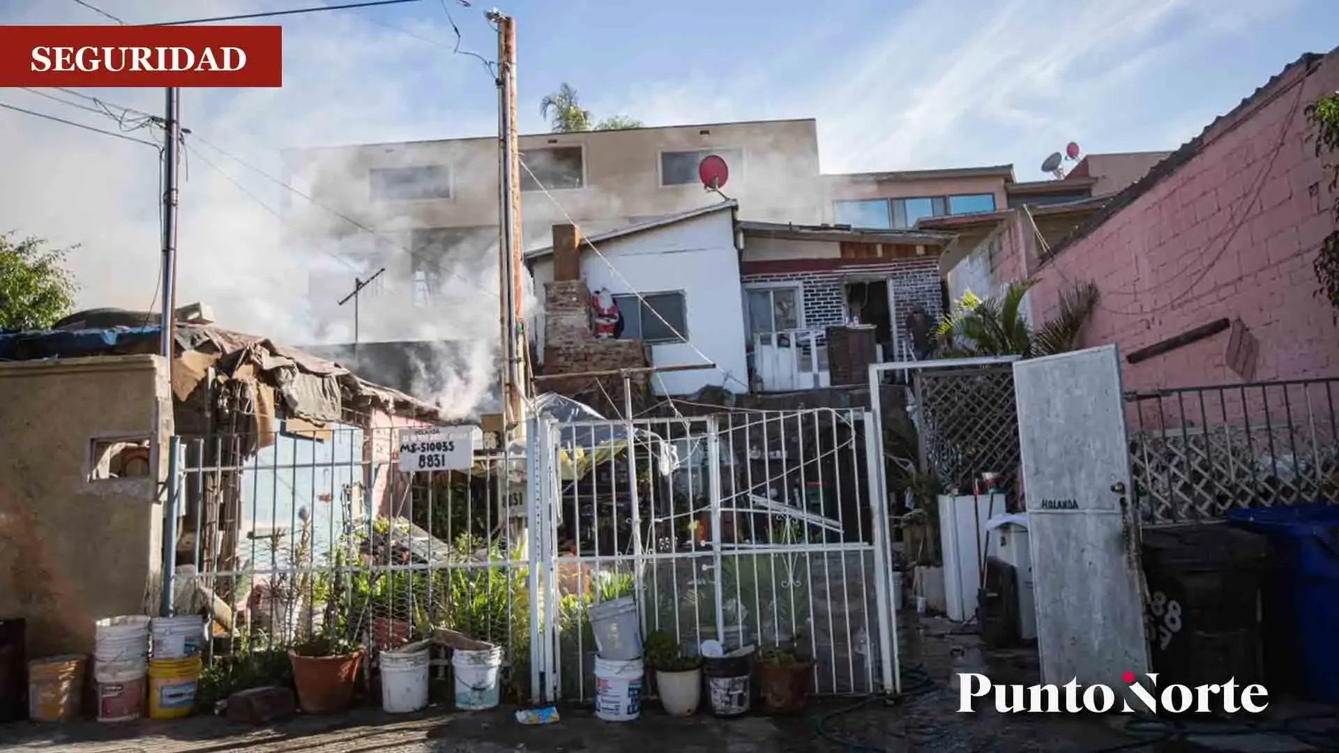 Bomberos evacuando a ciudadanos durante el incendio en Tijuana.