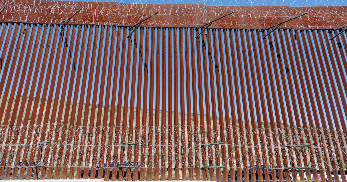 Grupo de migrantes intentando cruzar la frontera en Tijuana, enfrentando riesgos significativos.