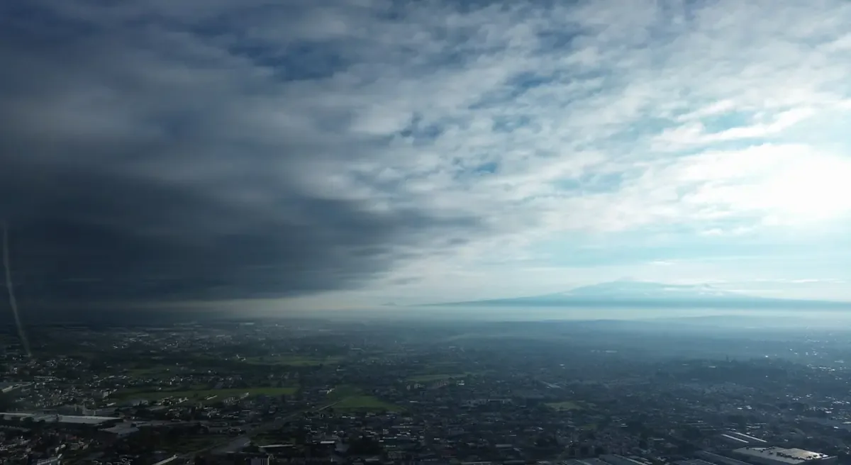 La ciudad muestra un cielo despejado en el este y nubes densas en el oeste, con lluvia esperada por la tarde.