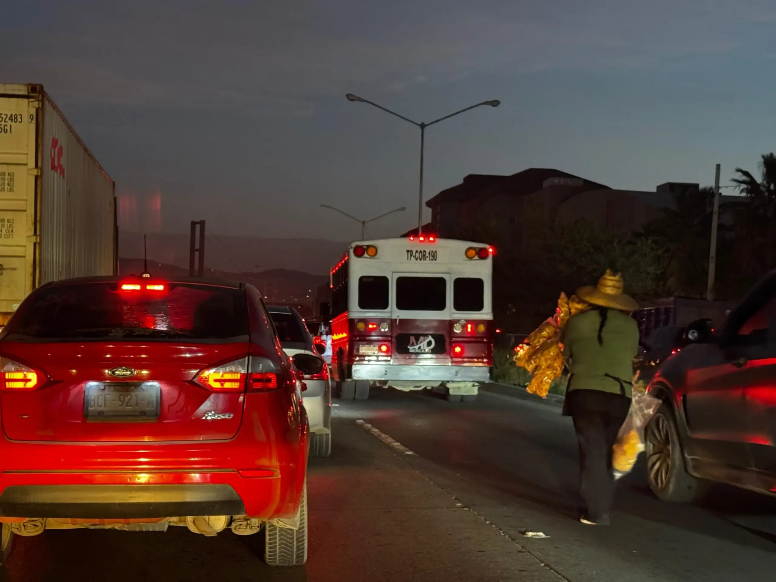 Vendedores ambulantes recorren filas de autos en la Vía Rápida de Tijuana.